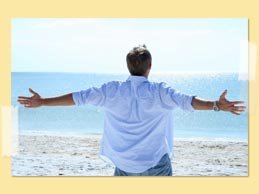 Image of man with his arms wide open to the sea